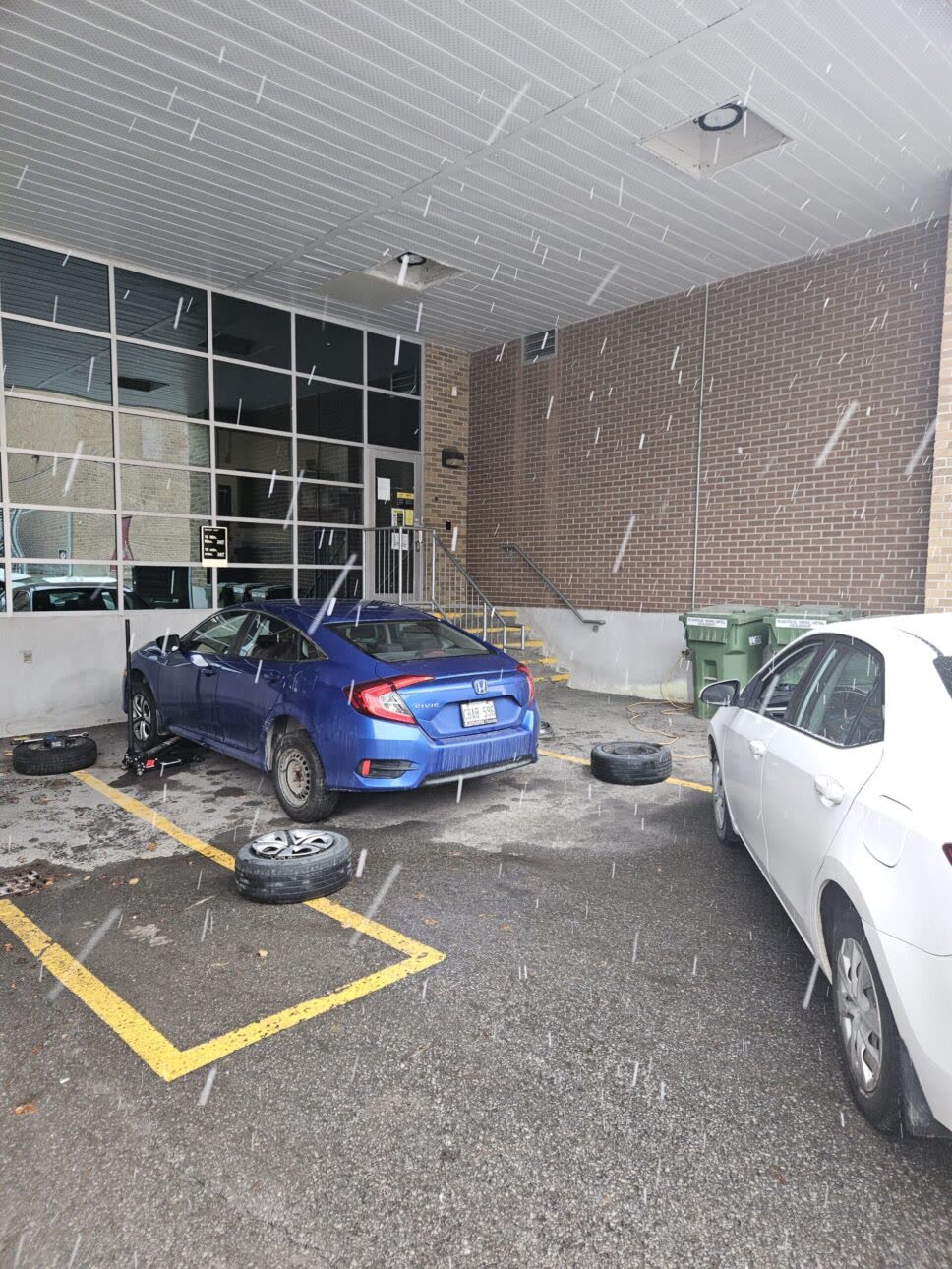 car with tires being changed during snowfall
